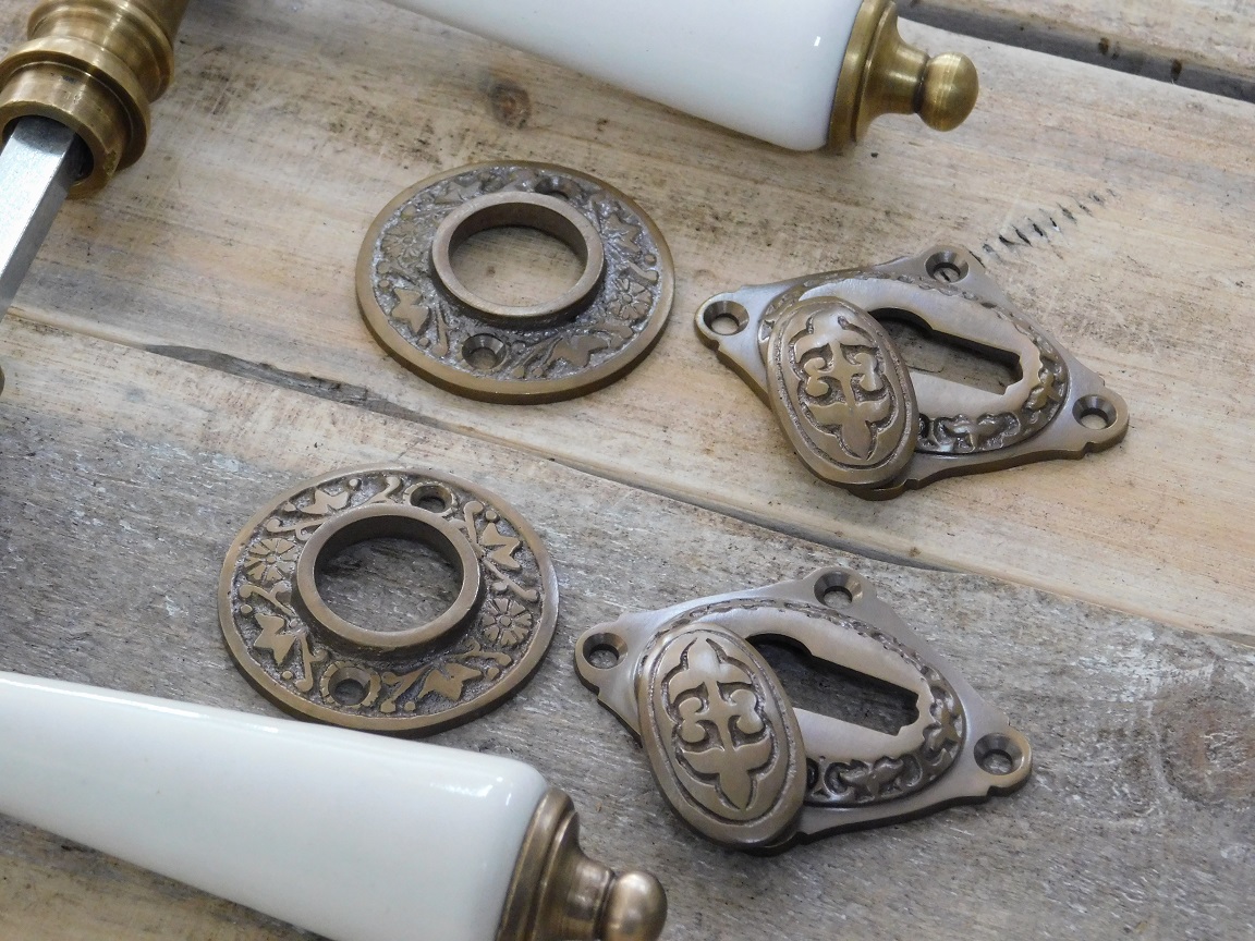 Ivoorkleurige porselein handgrepen deurkrukken met messing rozetten in historische stijl