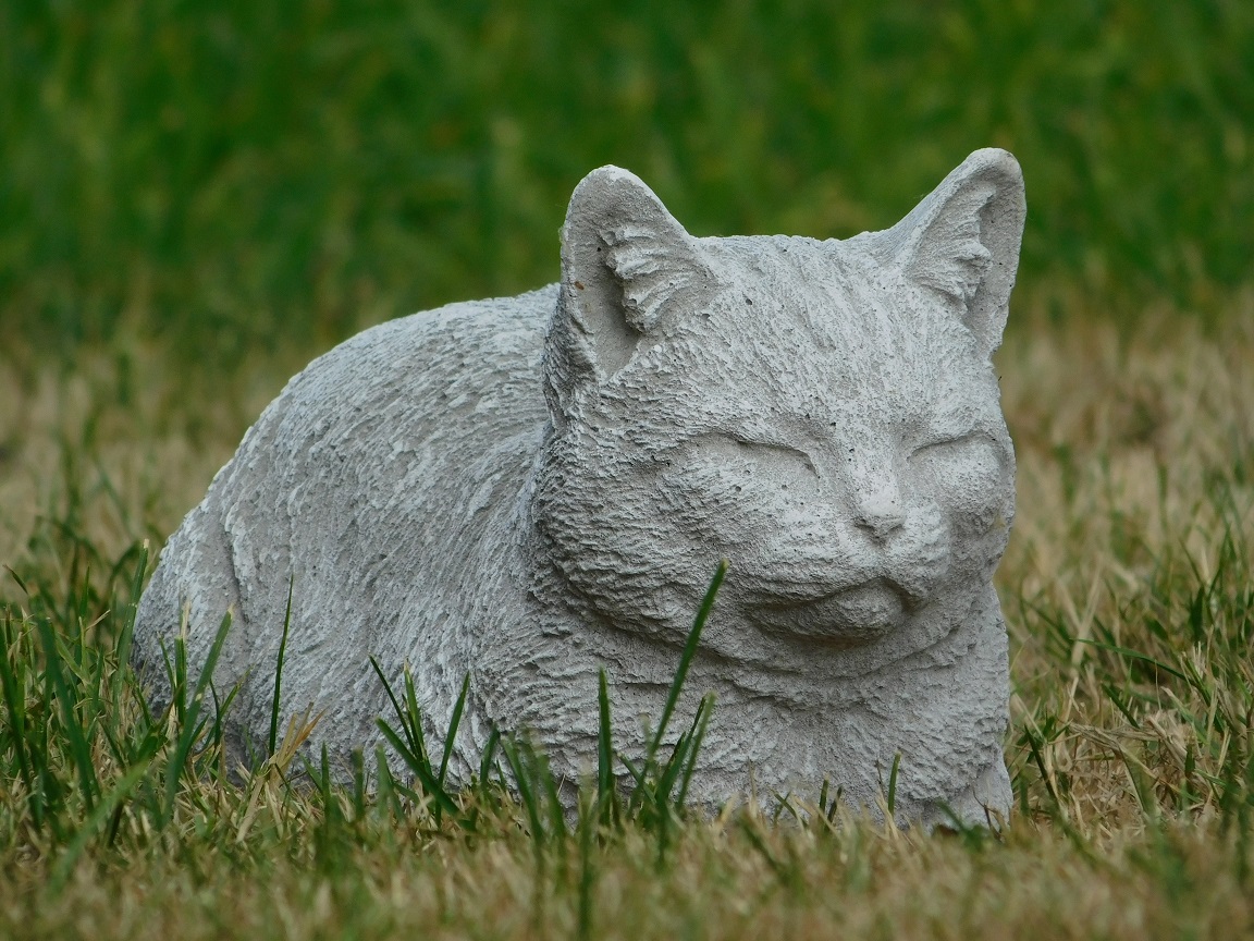 Statue of a lying cat - made entirely of stone - garden statue