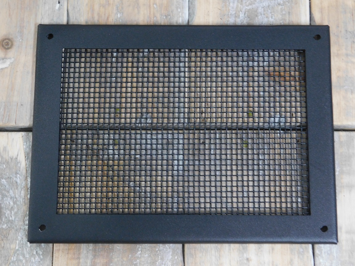 Een rechthoekig ventilatierooster met massief (fijn) gaas, mat zwart