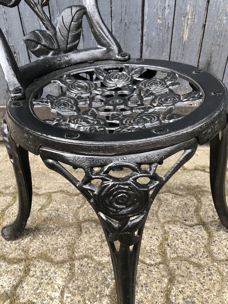 Cast iron heavy decorative chair in the colour black.