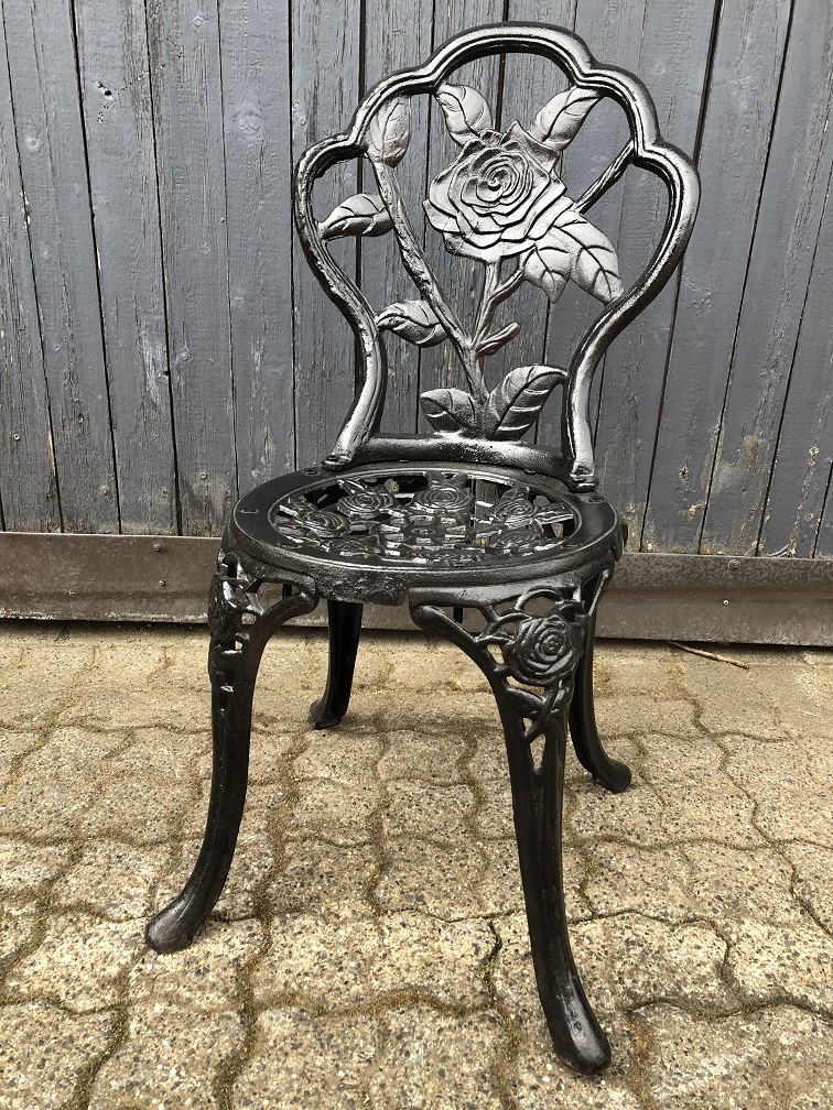 Schwerer dekorativer Stuhl aus Gusseisen in der Farbe Schwarz.