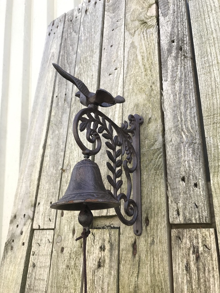Een sierlijke deurbel met een vogel erop, gemaakt van gietijzer