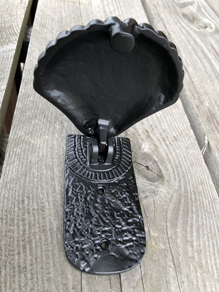 Decorative door knocker in the shape of a shell, all metal black.