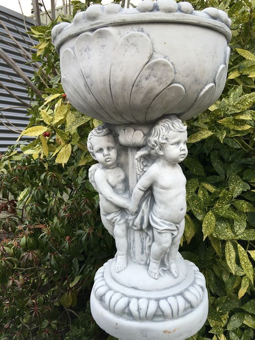 Prachtige zware bloempot-vaas uit vol steen gedragen door engelen.