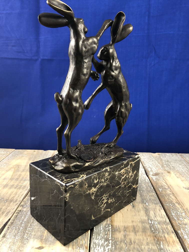 Bronzen beeld van 2 speelse hazen op marmer base.