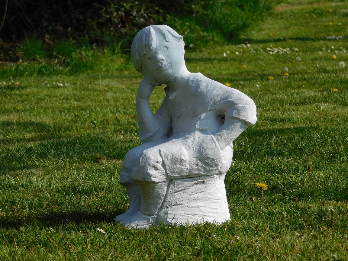 Statue sitzender Junge - massiver Stein