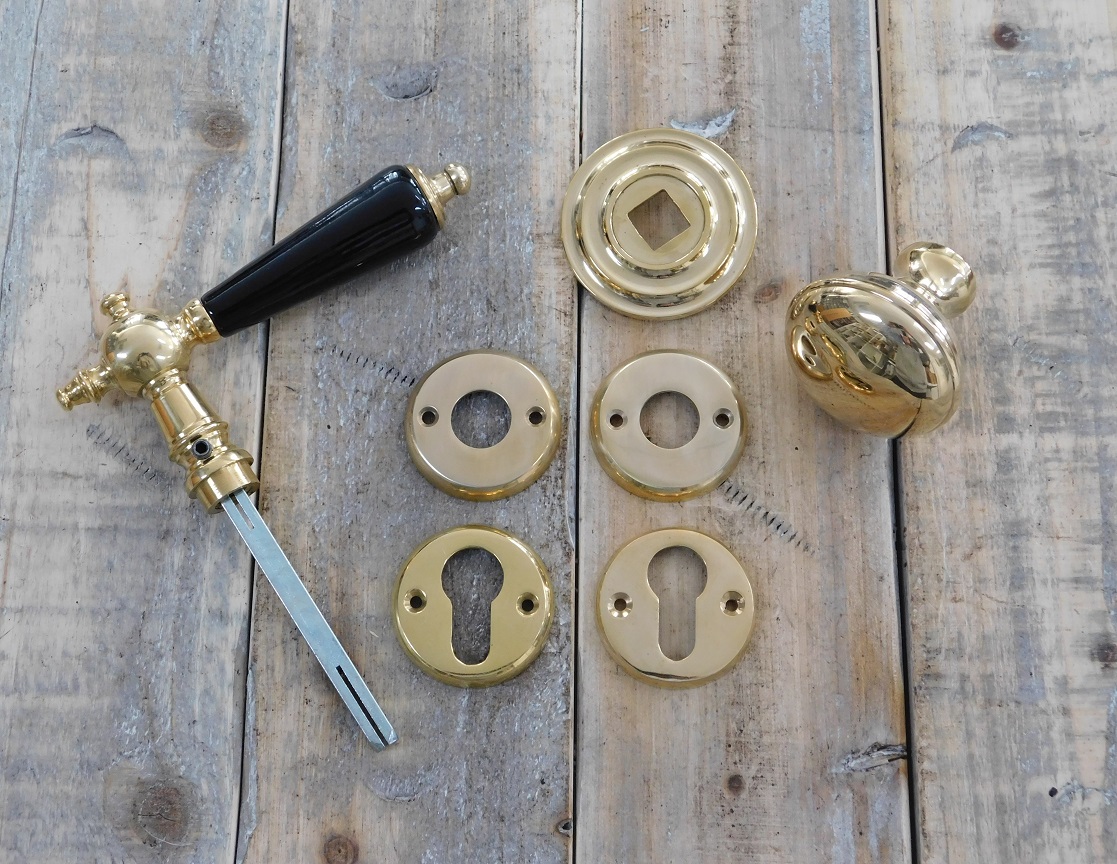 Deurbeslag set messing glans: klink met keramische handvat en messing deurknop op rozet en 2 x sleutelrozet.