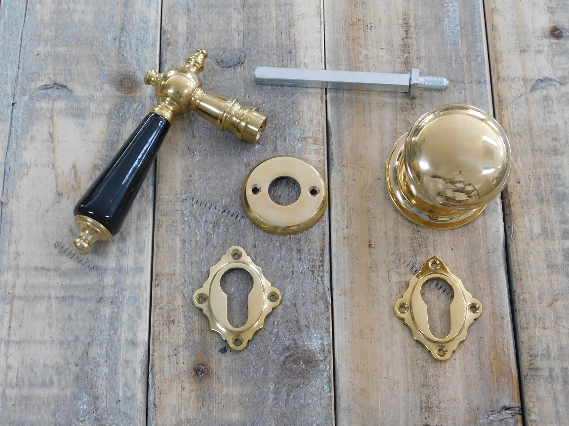 Deurbeslag set messing glans: klink met keramische handvat en messing deurknop op rozet en 2 x sleutelrozet.