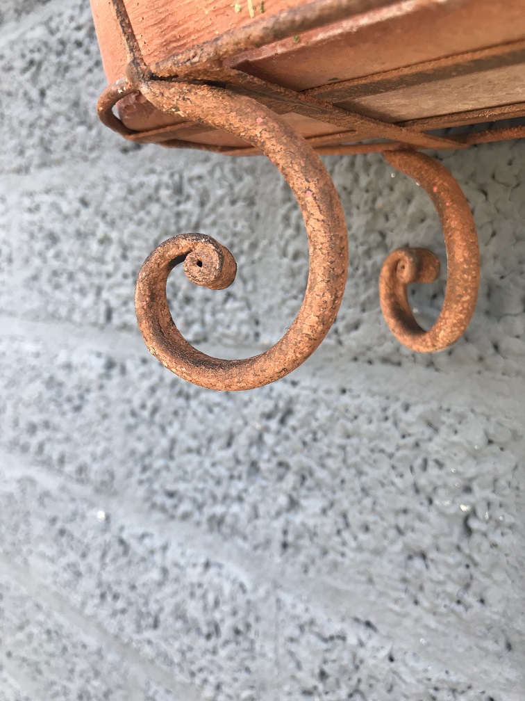 Rustiek metalen wandhouder met een bloembak, robuuste wanddecoratie