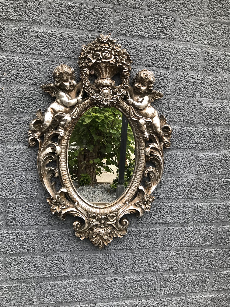 Een mooie decoratieve spiegel, zilveren omlijsting met krans gedragen door 2 engelen