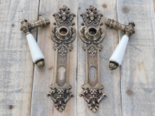 Set deurbeslag: messing, antiek- deurplaten zeer decoratief met engelen - klinken met wit porseleinen grepen.