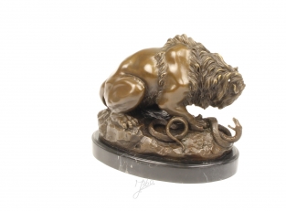 Een bronzen beeld van een leeuw en slang