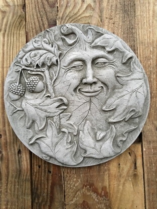 Wall ornament stone round, with an image of the cheerful oak leaf man, forest spirit.