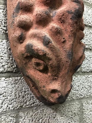 Wind light of roof tile with mythical image, with candlestick and glass flask.