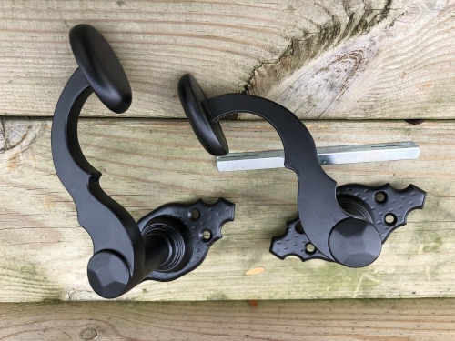 Mooi zwart metalen deurbeslagset, met geveerde sluiting op de rozetten.