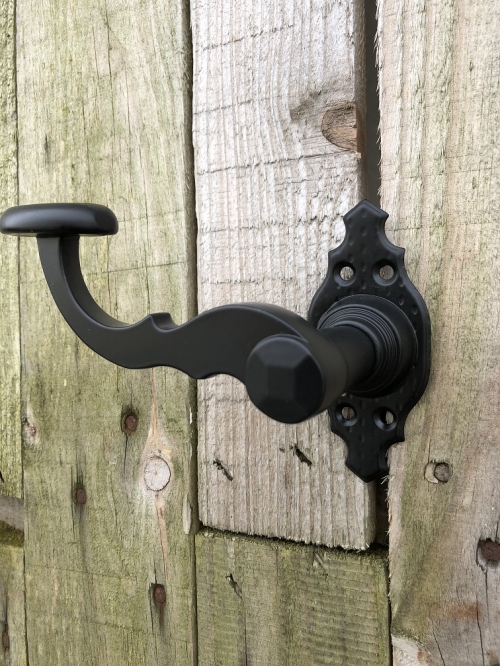 Mooi zwart metalen deurbeslagset, met geveerde sluiting op de rozetten.