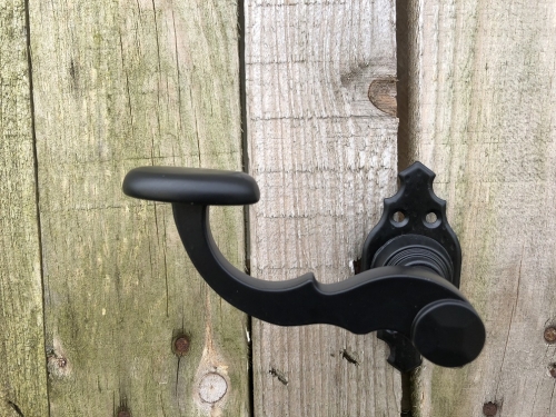 Mooi zwart metalen deurbeslagset, met geveerde sluiting op de rozetten.