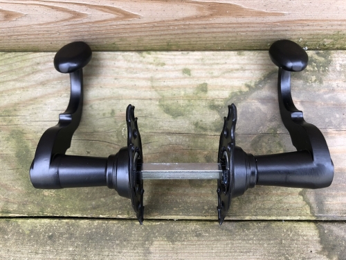 Mooi zwart metalen deurbeslagset, met geveerde sluiting op de rozetten.