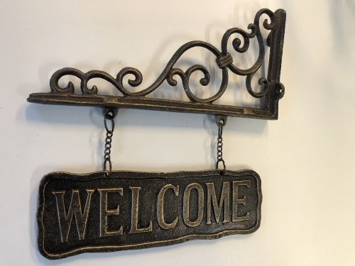 Uithangbord-wandbord aan mooie handbeugel, metaal, bronskleur, met de tekst: WELCOME.