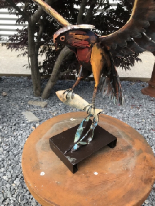 Ein Metallkunstwerk eines Adlers, der einen Fisch fängt, ''IRON EAGLE''.