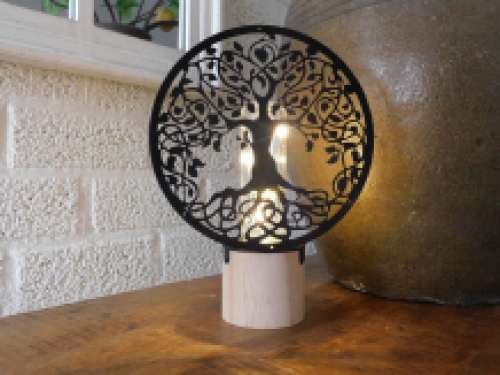 Hübsche Lampe mit einem ornamentalen Lebensbaum vor der Lampe.