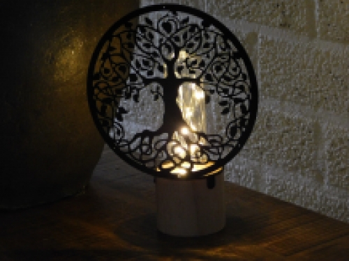 Hübsche Lampe mit einem ornamentalen Lebensbaum vor der Lampe.