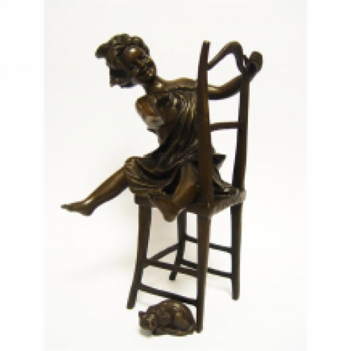 Een bronzen beeld/sculptuur van een blij kind, zittend op een stoel