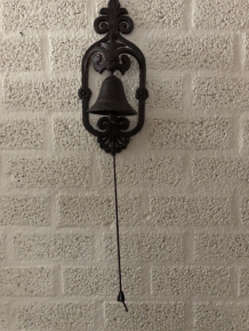 Prachtig wandornament met een mooie deurpost bel met koord en klingel, cast iron bruin.