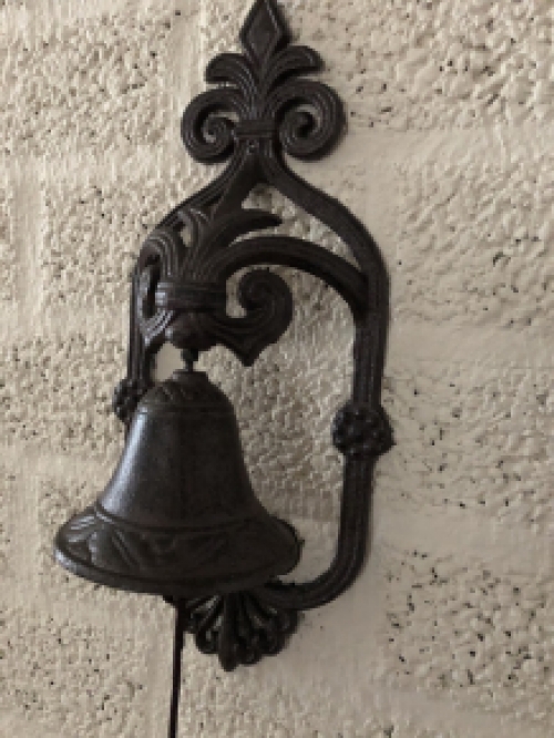 Prachtig wandornament met een mooie deurpost bel met koord en klingel, cast iron bruin.