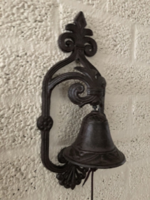 Prachtig wandornament met een mooie deurpost bel met koord en klingel, cast iron bruin.