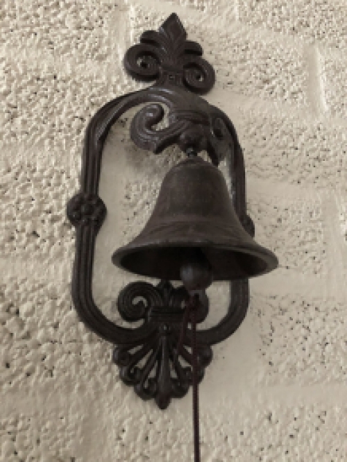 Prachtig wandornament met een mooie deurpost bel met koord en klingel, cast iron bruin.