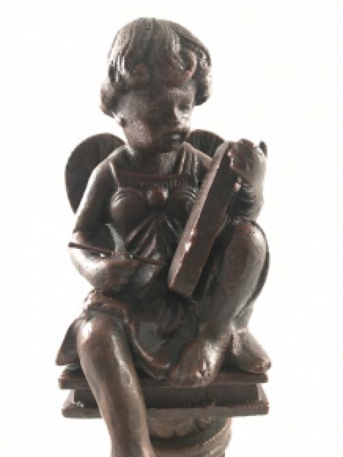 Intact statue of an angel sitting on a pedestal writing, cast iron