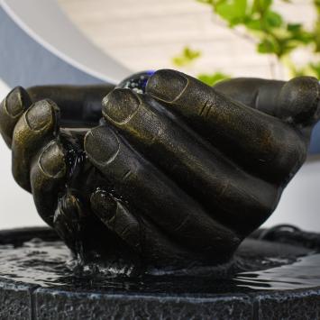 Indoor fountain, hands as bowl, illuminated water ornament