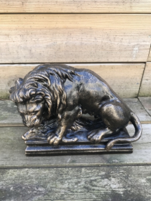 A beautiful statue of a lion with its prey, a boar, made of cast iron, bronze look!