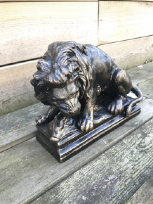 A beautiful statue of a lion with its prey, a boar, made of cast iron, bronze look!