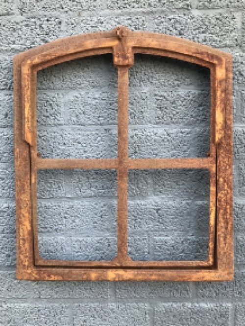 An antique-looking stable window, foldable open, untreated cast iron, resting surface, window