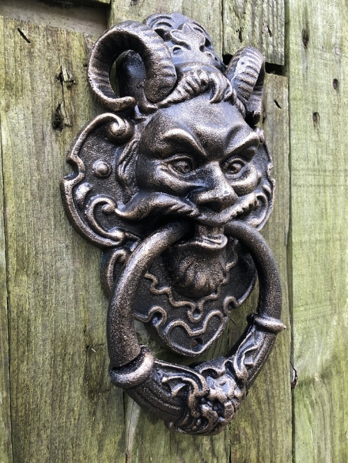 Cast iron bronze door knocker with devil's head.