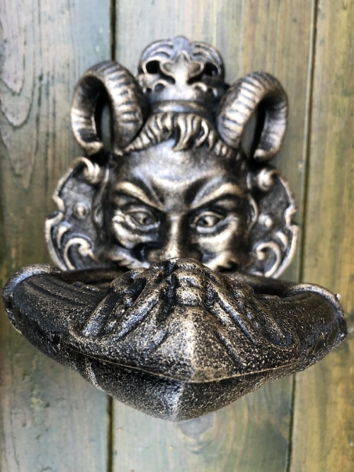 Cast iron bronze door knocker with devil's head.