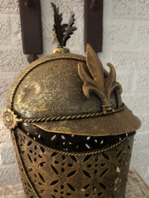 A beautiful metal brass knight helmet on stand.