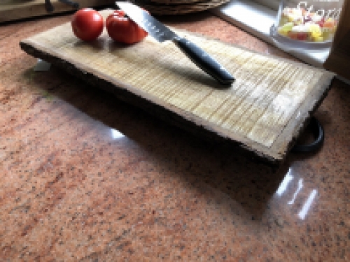 Mooie rustieke snijplank gemaakt van massief hout, nostalgische keukenplank, met metalen beugels.