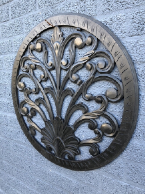 Wall ornament round, decoratively carved, black-brown.