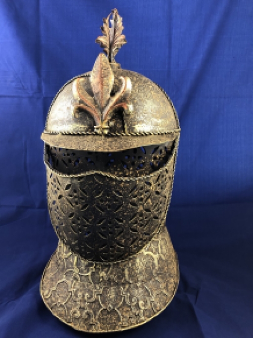 A beautiful metal brass knight helmet on stand.