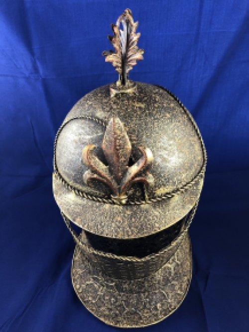 A beautiful metal brass knight helmet on stand.