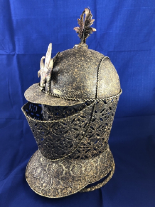 A beautiful metal brass knight helmet on stand.