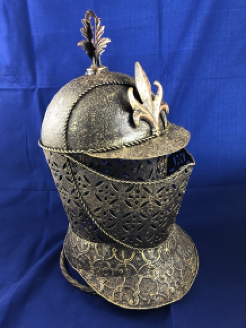 A beautiful metal brass knight helmet on stand.