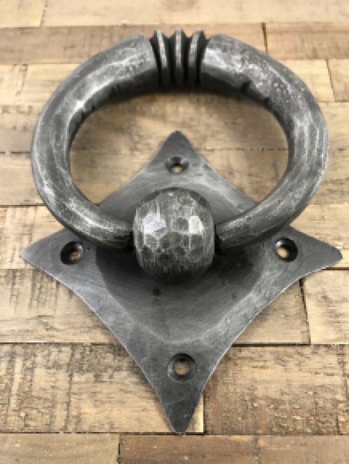 Pull-ring - door knocker wrought iron for on the rustic wooden door, convent door, country house door.