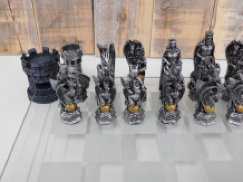 A chess game with the theme: ''knight-dragons'', beautiful chess pieces like medieval knights on glass chessboard with rooks.