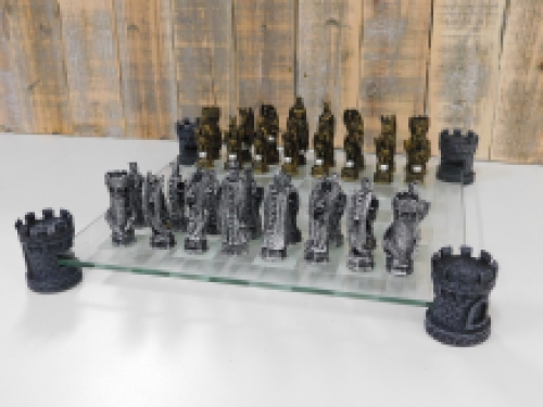 A chess game with the theme: ''knight-dragons'', beautiful chess pieces like medieval knights on glass chessboard with rooks.