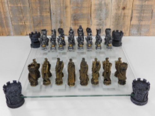 A chess game with the theme: ''knight-dragons'', beautiful chess pieces like medieval knights on glass chessboard with rooks.