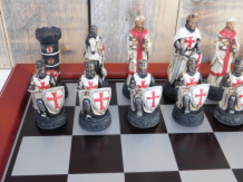 Ein Schachspiel mit dem Thema: ''MEDIEVAL KNIGHTS'', schöne Schachfiguren als mittelalterliche Ritter auf einem hölzernen Schachbrett.